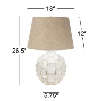 This classic midcentury modern table lamp features a handsome ceramic base with a dramatic design The resulting look is full and rich with a texture that is both eyecatching and stylishly sculpted Its topped with a linen drum shade that provides a natural