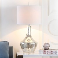 Cast a romantic glow in your living room or bedroom with the transitional silver mercury table lamp by Safavieh Inspired by vintage mercury glass the silvery crackle glass urnshaped base is contrasted by a crisp white cotton contemporary drum shade