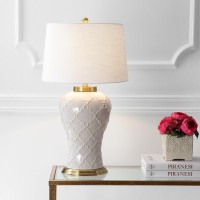 Featuring a creamcolored glaze and quatrefoil trellis texture this transitional table lamp boasts modern elegance to complement any contemporary decor The hardback linen shade offers sleek contrast to the textured base while the brass pedestal fittings an