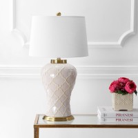 Featuring a creamcolored glaze and quatrefoil trellis texture this transitional table lamp boasts modern elegance to complement any contemporary decor The hardback linen shade offers sleek contrast to the textured base while the brass pedestal fittings an