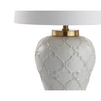 Featuring a creamcolored glaze and quatrefoil trellis texture this transitional table lamp boasts modern elegance to complement any contemporary decor The hardback linen shade offers sleek contrast to the textured base while the brass pedestal fittings an