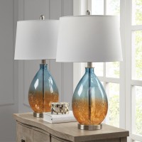 pUpdate your space with the sleek style of the Cortina Table Lamp The metal and blue glass base give the lamp a striking sleek look The white tapered drum shaped shade softly filters the light while also beautifully complementing the look This table lamp 