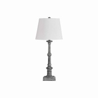 Illuminate your existing decor setting by bringing in this transitional style Table Lamp which comes with a tapered drum shade and rests on turned wooden frame with a pedestal base Wrapped with white color fabric it is accented with gray color finish