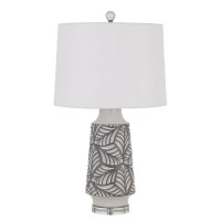 Add a tropical vibe to your space with this white ceramic leaf print table lamp It features a milky ceramic finish with gray painted accents and solid crystal base The look is completed with a white fabric shade and matching finial