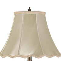 Add style and elegance at the same time with the inclusion of this table lamp The turned pedestal style body with brass hue and leaf accents brings the most enchanting look in the interior setting and fills your ambience with whimsical appeal The scallope