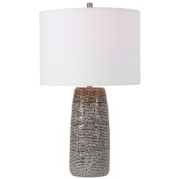 Classic and stylish on its own this table lamp showcases clean lines and creativity Resting atop round base it has vase shaped body with brick pattern which adds to the overall beauty The round shaped fabric shade allows the light to filter through and cr