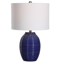 Classic and stylish on its own this table lamp showcases clean lines and creativity Crafted from ceramic it has jar shaped body with ribbed design which adds to the overall beauty The round shaped fabric shade allows the light to filter through and create