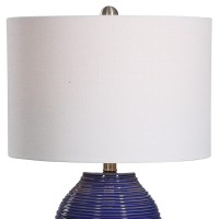 Classic and stylish on its own this table lamp showcases clean lines and creativity Crafted from ceramic it has jar shaped body with ribbed design which adds to the overall beauty The round shaped fabric shade allows the light to filter through and create