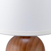 Perfect for bedroom office or living room this stylish table lamp elevates the aesthetics of your interior setting Incorporating a fabric shade in a bell shape it comes with a wooden base in a spherical shape with visual patterns This simple and sophistic