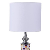 Brighten up your aesthetics like never before with the inclusion of this table lamp Crafted from metal it has a cylindrical body with a glass cut out mosaic pattern that adds to the beauty The uno fitter shade allows the light to filter through it The on 