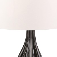 Introduce a dash of elegance and creativity to your living room or bedrooms with this table lamp With a bowling pin shape in the body and textured faceted vertical lines this artistic piece includes a tapered fabric shade that comes together to create a p