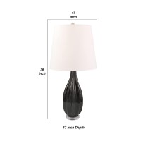 Introduce a dash of elegance and creativity to your living room or bedrooms with this table lamp With a bowling pin shape in the body and textured faceted vertical lines this artistic piece includes a tapered fabric shade that comes together to create a p