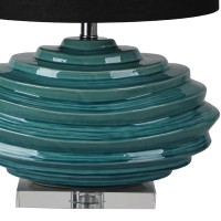 DescriptionAdd some dramatic but confident color to your favorite room with this uniquely crafted table lamp The elongated drum fabric shade rests atop the artistic faceted spiral base that is truly enticing to the eyes The blue green aqua hue gives a ple