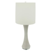 This unique and well crafted table lamp is inspired by seashells with its tapered and textured white ceramic body The white finished drum shade adds a sense of cleanliness and serenity to the naturalistic looking piece The piece has a calm and simple aura