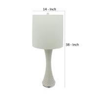 This unique and well crafted table lamp is inspired by seashells with its tapered and textured white ceramic body The white finished drum shade adds a sense of cleanliness and serenity to the naturalistic looking piece The piece has a calm and simple aura